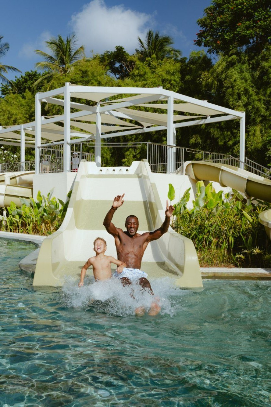 A father and son splashing down one of the four slides at the Aquazone Water Theme Park, Paradisus by Meliá Bali