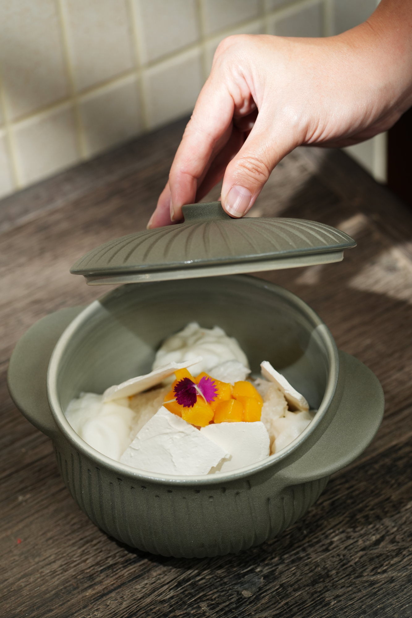A coconut dessert with mango served in a lidded ceramic pot at ARUM, Paradisus by Melia Bali