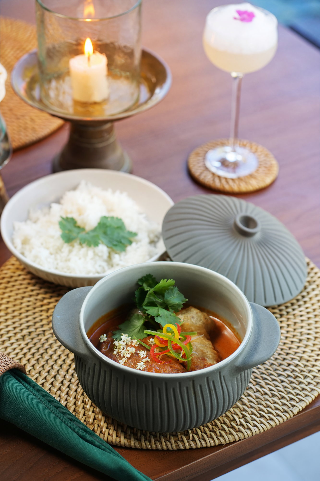 A red curry served in a ceramic pot with steamed rice by candlelight at ARUM, Paradisus by Melia Bali