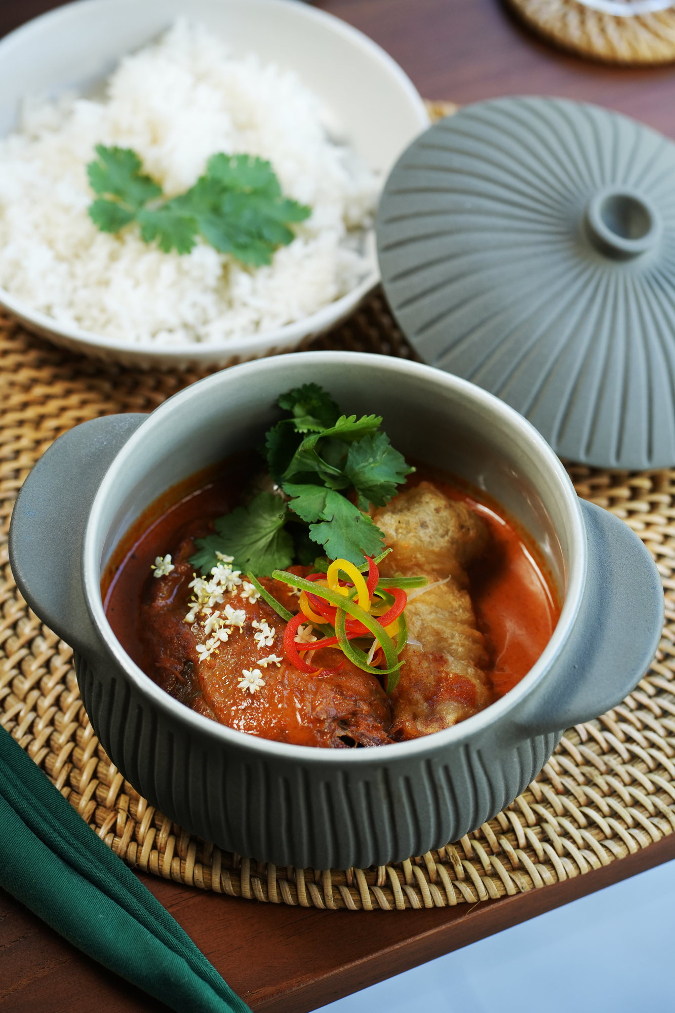 A red curry with fried tofu and sliced chilli in a ceramic pot at ARUM, Paradisus by Melia Bali