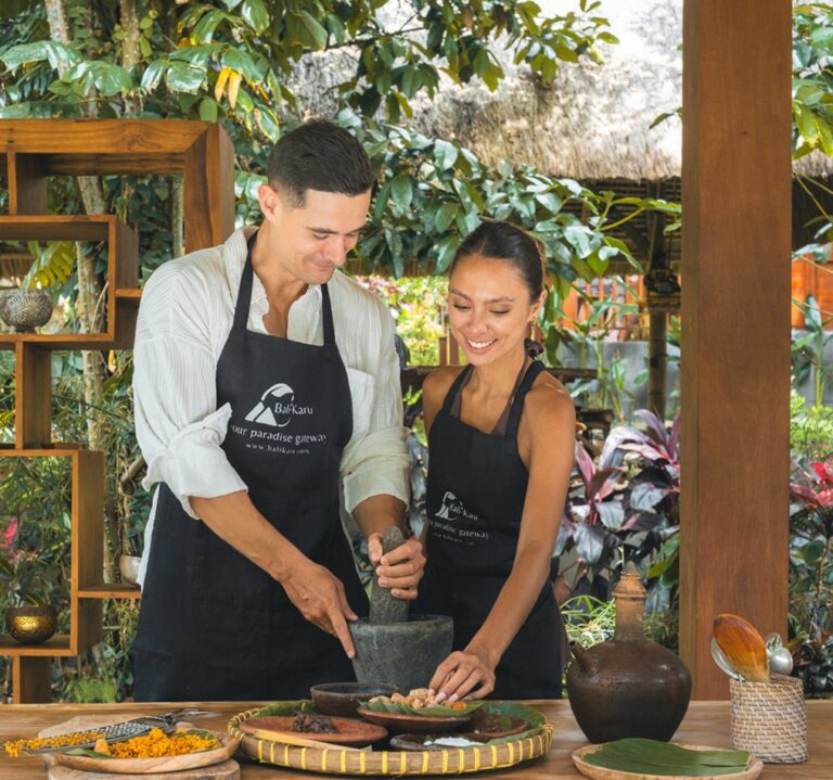 Guests grinding Balinese spices with a stone mortar during the Balikaru Village Experience on Mount Batukaru