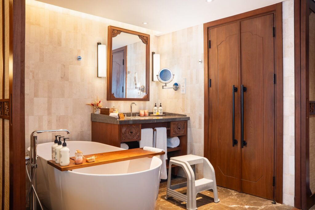 A child-sized bathroom step beside the freestanding bathtub in a Family Concierge suite