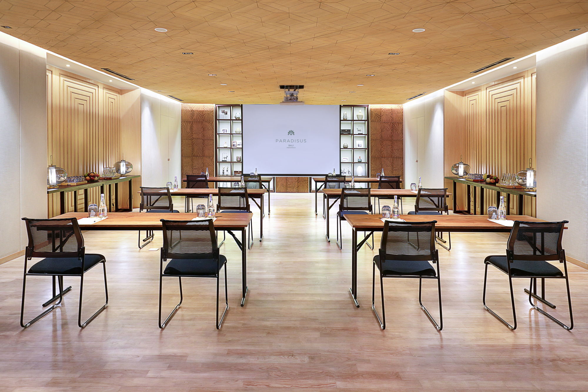The Bedugul Room at Paradisus by Meliá Bali in classroom set-up, with a projection screen, timber-panelled walls and a patterned wooden ceiling