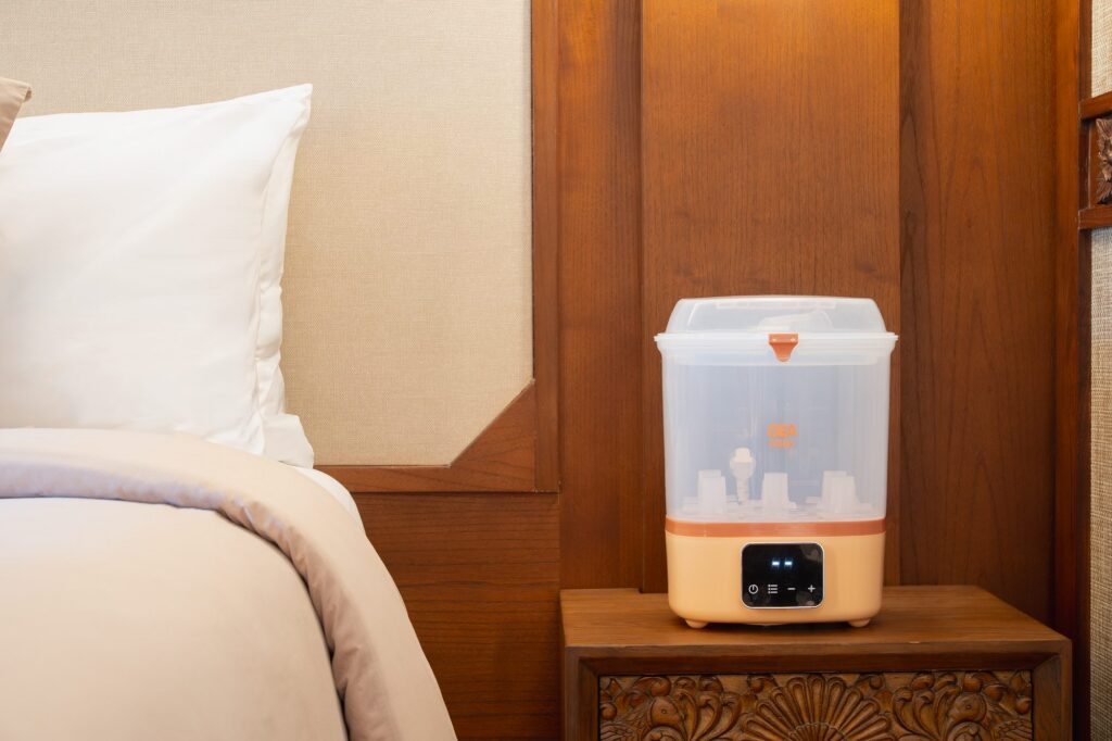 A bottle sterilizer and warmer on the bedside table of a Family Concierge suite