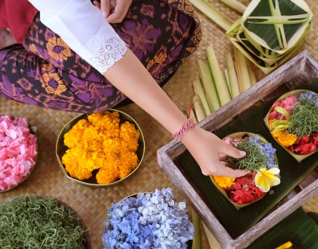 Making canang sari, the daily Balinese flower offering, with marigolds, hydrangea and frangipani