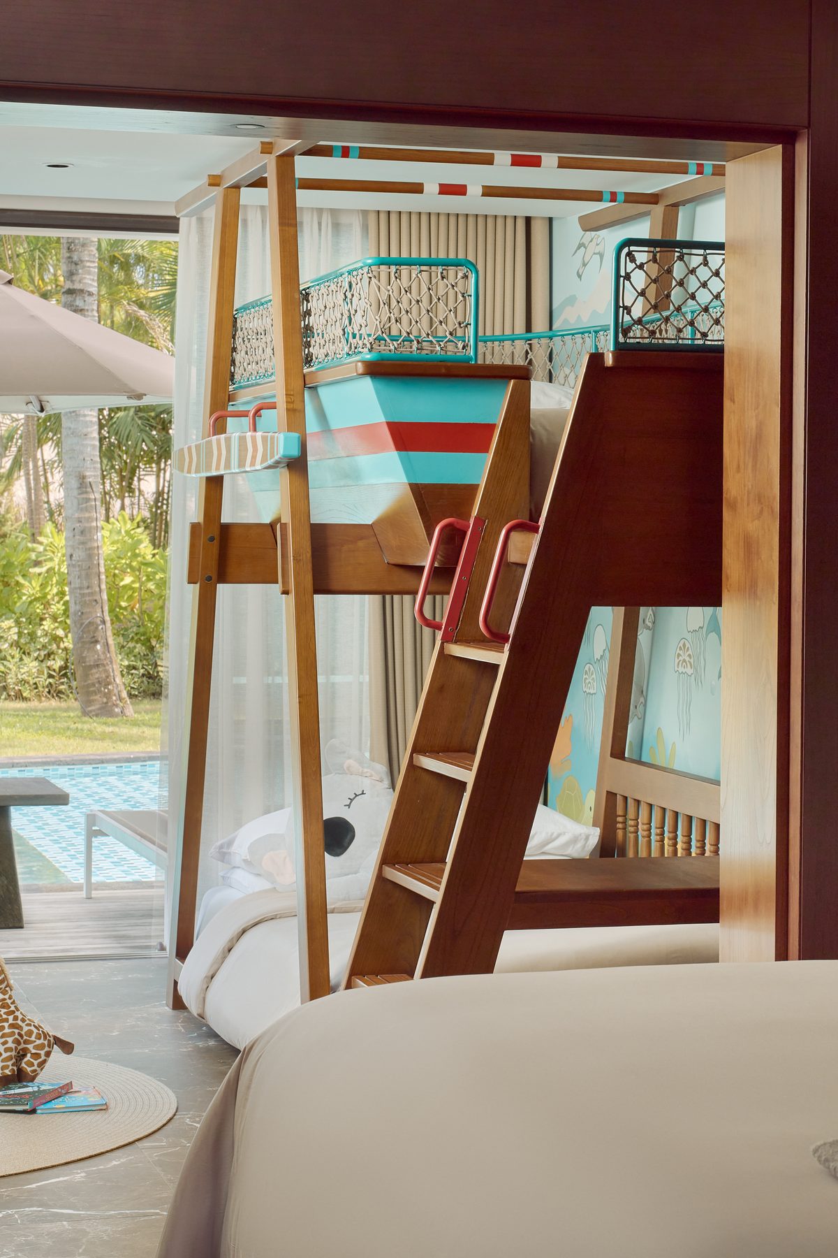 A Family Concierge Junior Suite Lagoon Access at Paradisus by Meliá Bali, with a boat-shaped bunk bed for children and steps out to the lagoon pool