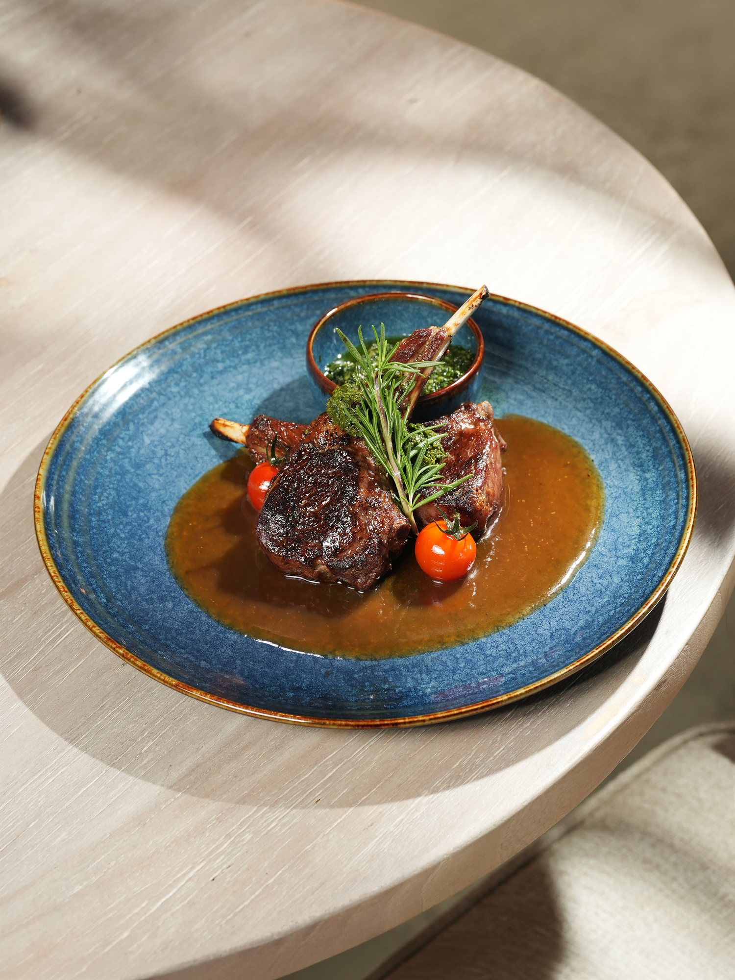 Grilled lamb chops with rosemary, cherry tomatoes and a herb sauce at Kanna Beach, Paradisus by Melia Bali
