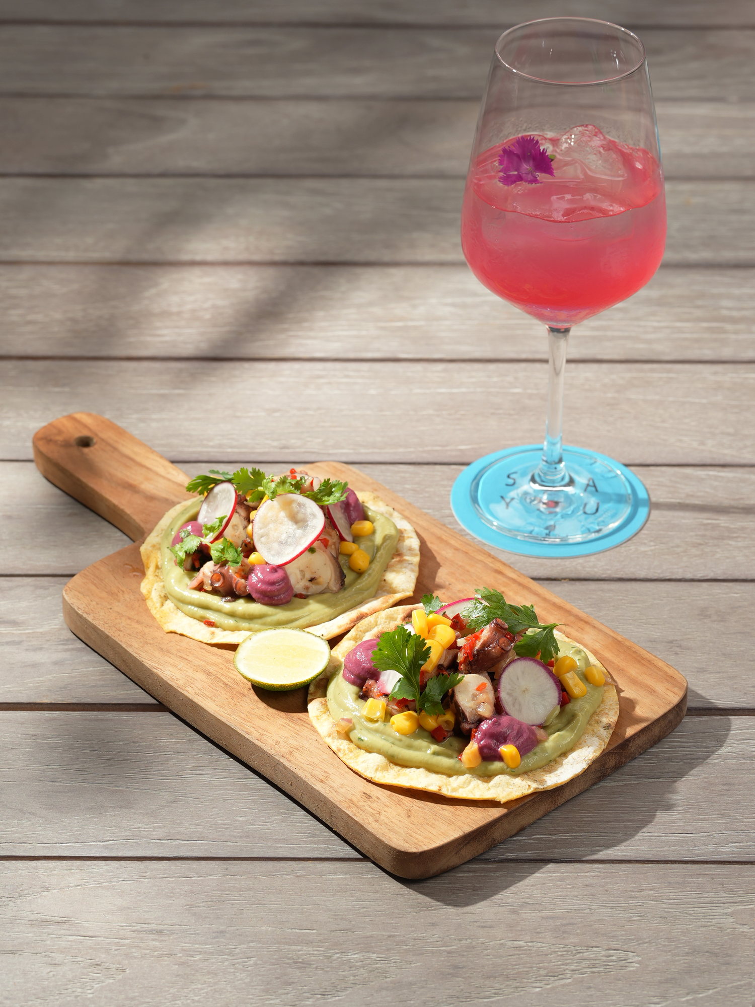 Octopus tostadas with avocado, corn and radish on a wooden board at Kanna Beach, Paradisus by Melia Bali