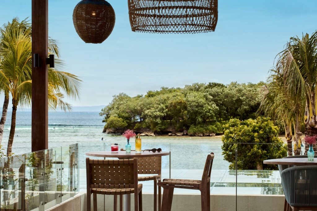 Cocktails on a table at Kanna Rooftop Bar, Paradisus by Meliá Bali, looking over the lagoon to the sea