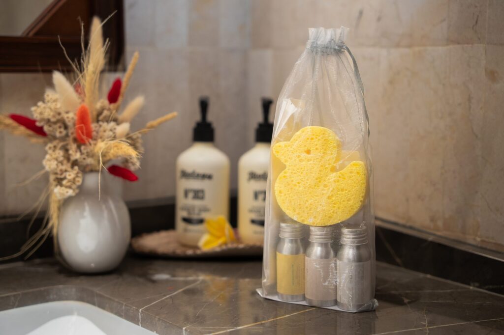 The kids amenities kit with a duck-shaped bath sponge and small bottles, on the bathroom counter