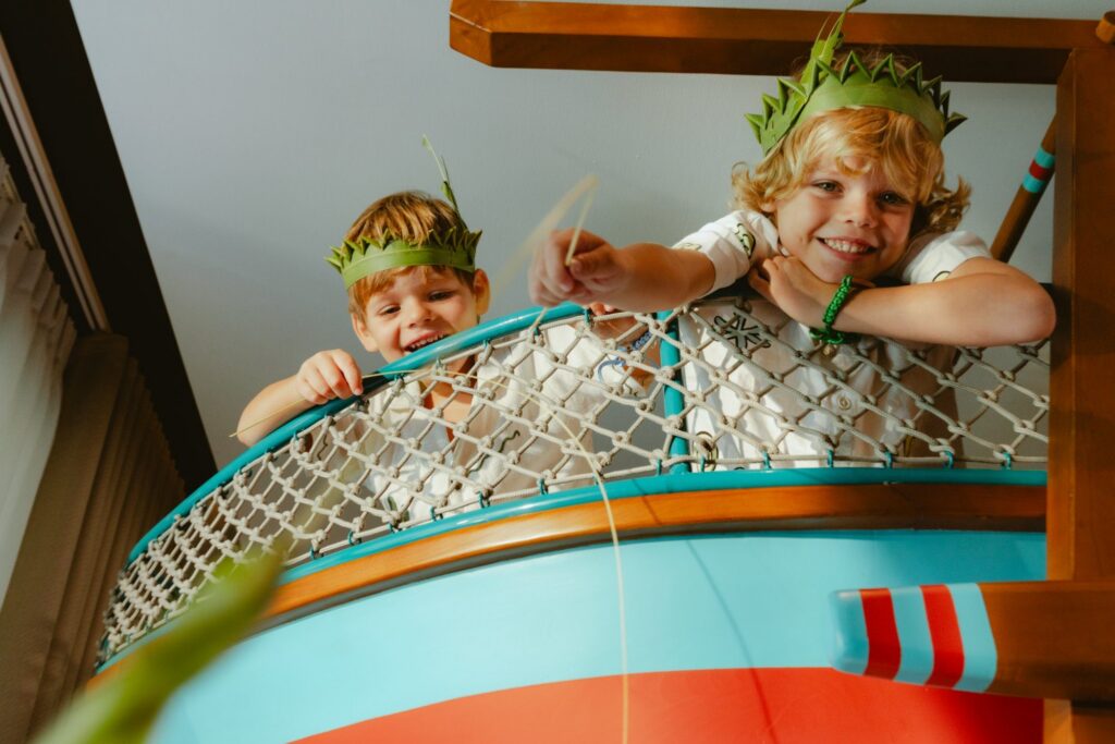 Two children in leaf crowns playing in the boat-shaped bunk bed of a Family Concierge suite at Paradisus by Meliá Bali