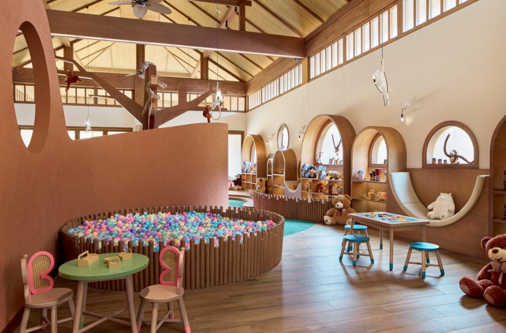 Inside Kidsdom by Aquazone at Paradisus by Meliá Bali, with a ball pit, craft tables and toy-filled alcoves under a high timber roof