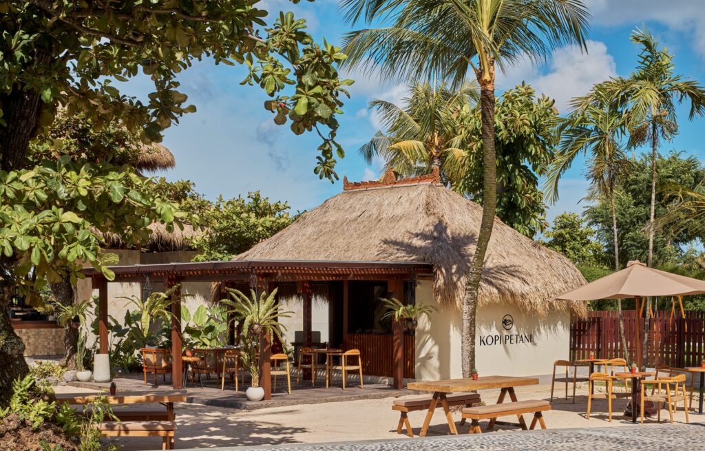 Kopi Petani coffee shop at Paradisus by Meliá Bali, a thatched pavilion with outdoor tables on the sand