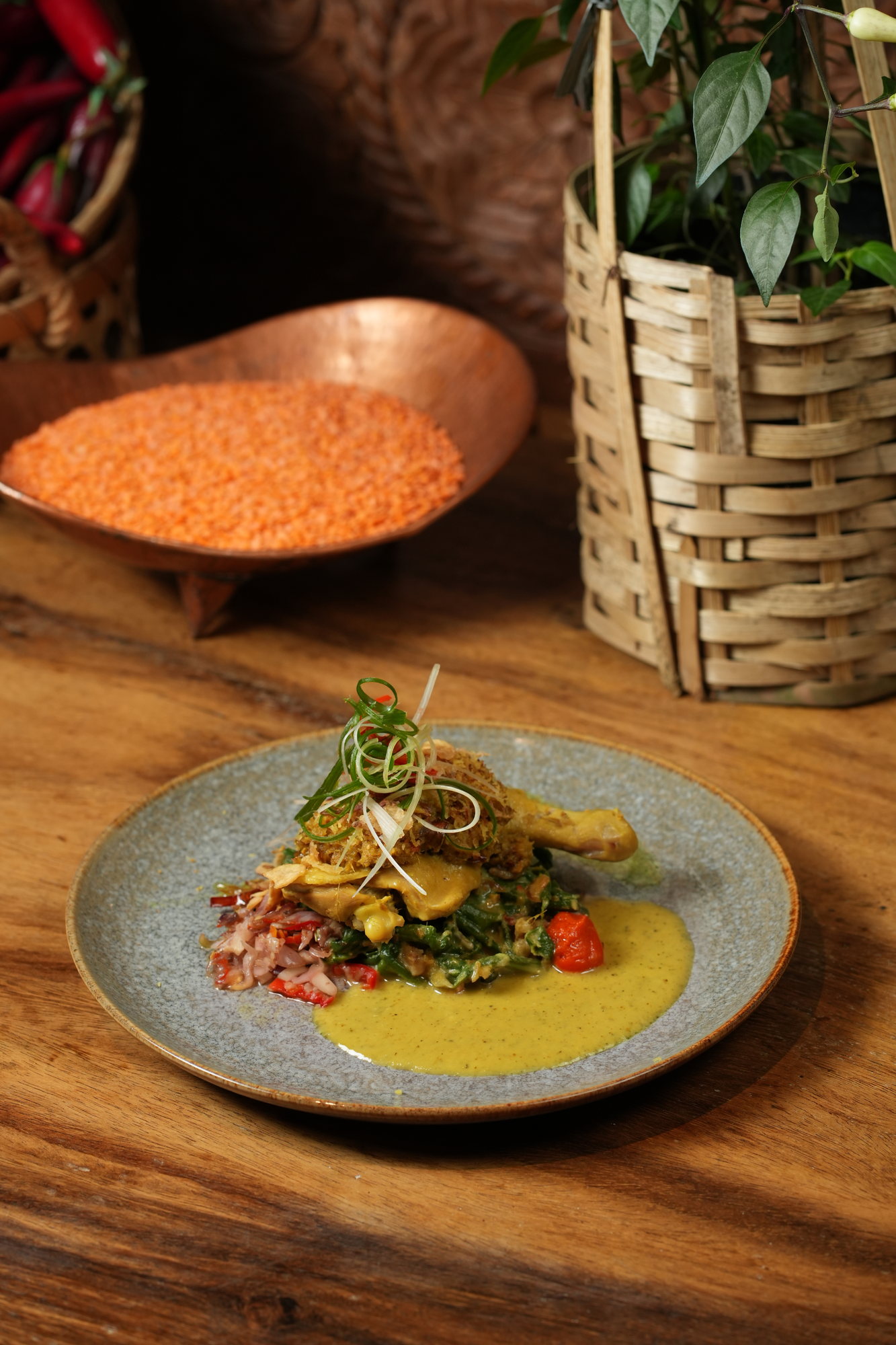 Chicken leg in a yellow curry sauce with braised greens and crisp shallots at Malva, Paradisus by Melia Bali