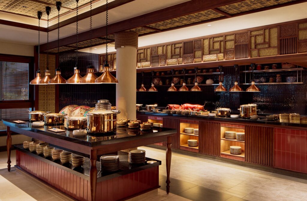The buffet counters at Malva restaurant, Paradisus by Meliá Bali, with copper heat lamps and a suckling pig carving station