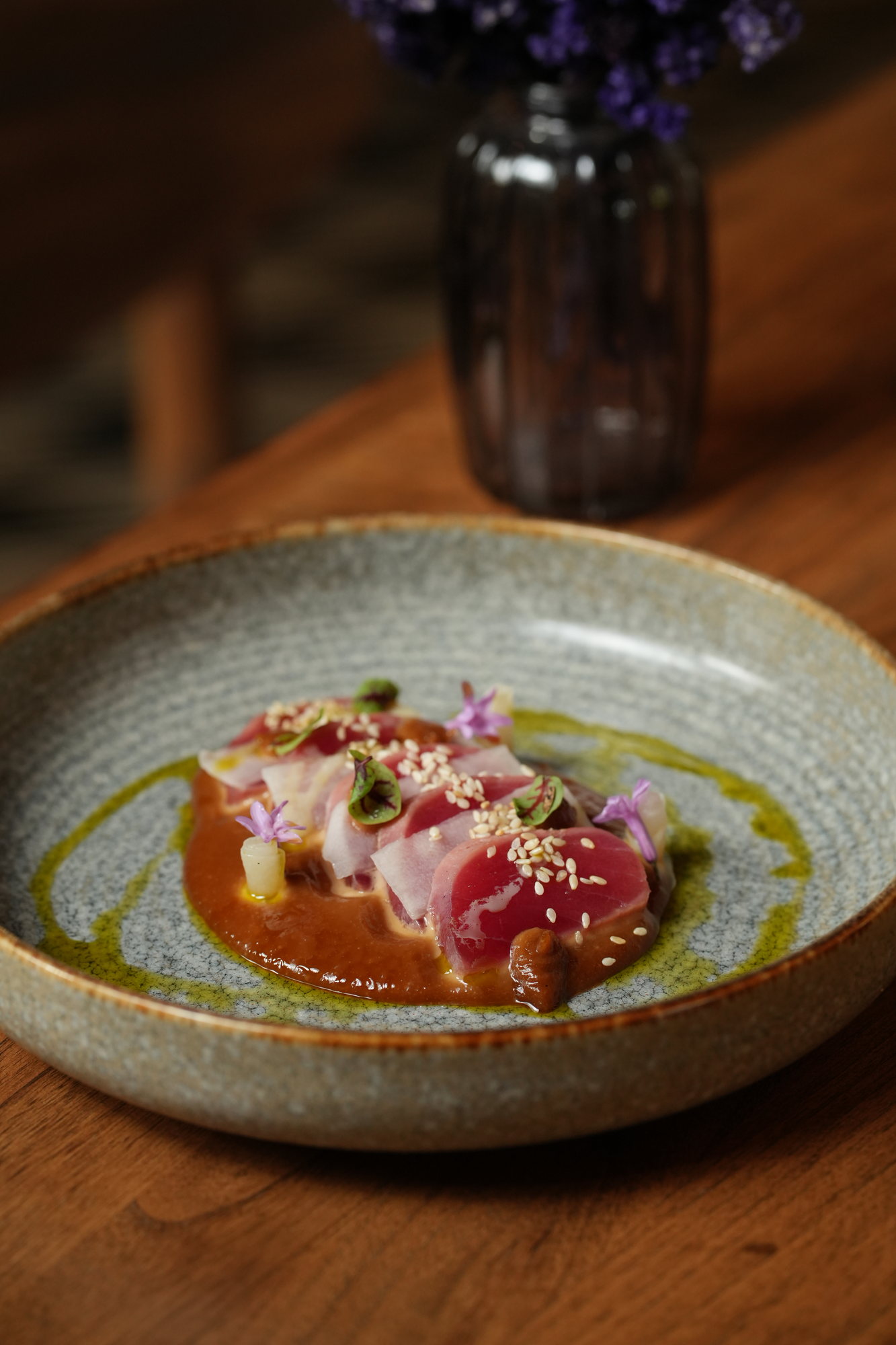 Sliced tuna with sesame seeds on a peanut sauce with herb oil at Malva, Paradisus by Melia Bali