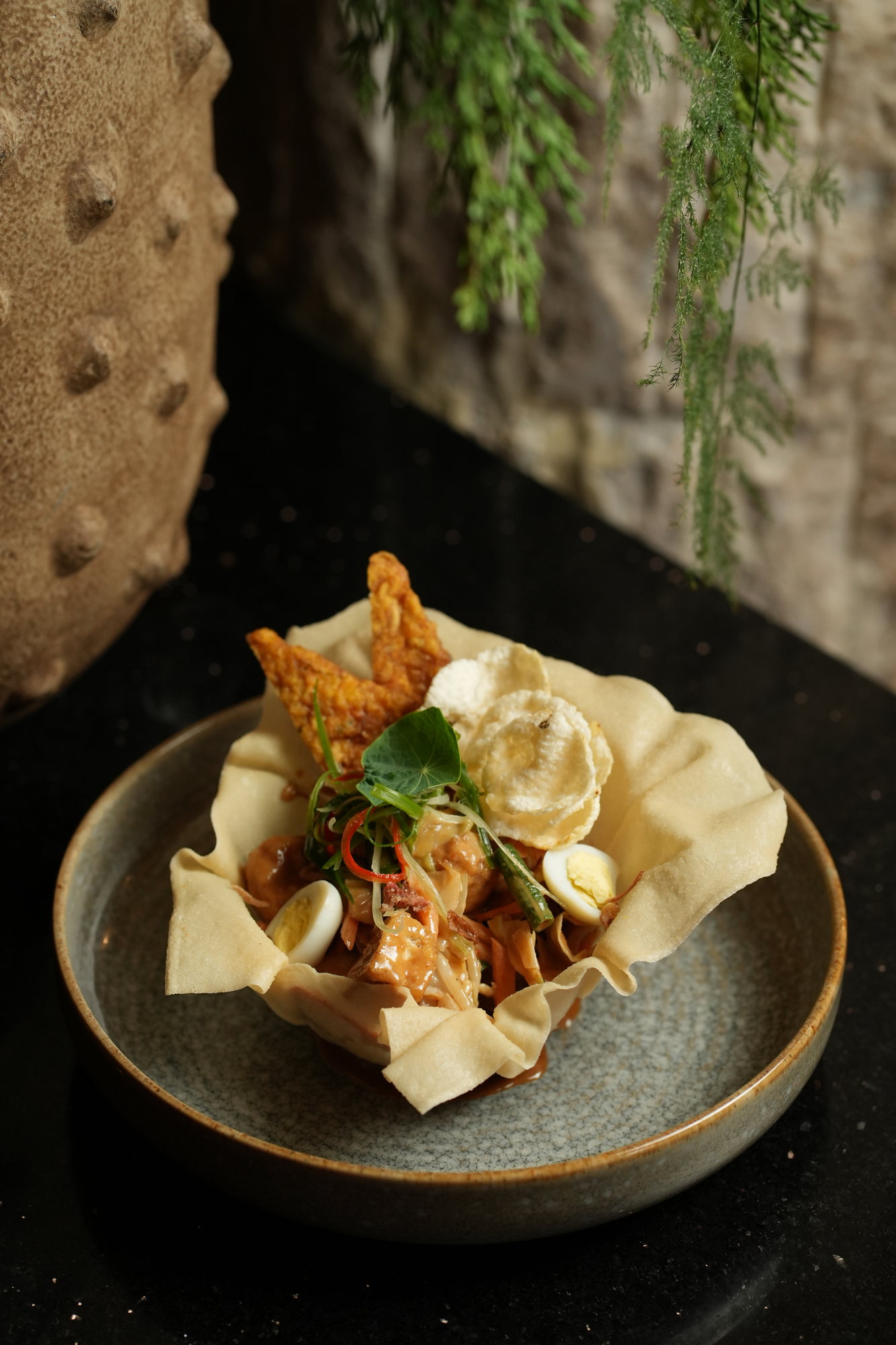 A vegetable salad with peanut sauce, quail egg, tempeh and crackers served in a crisp pastry basket at Malva, Paradisus by Melia Bali