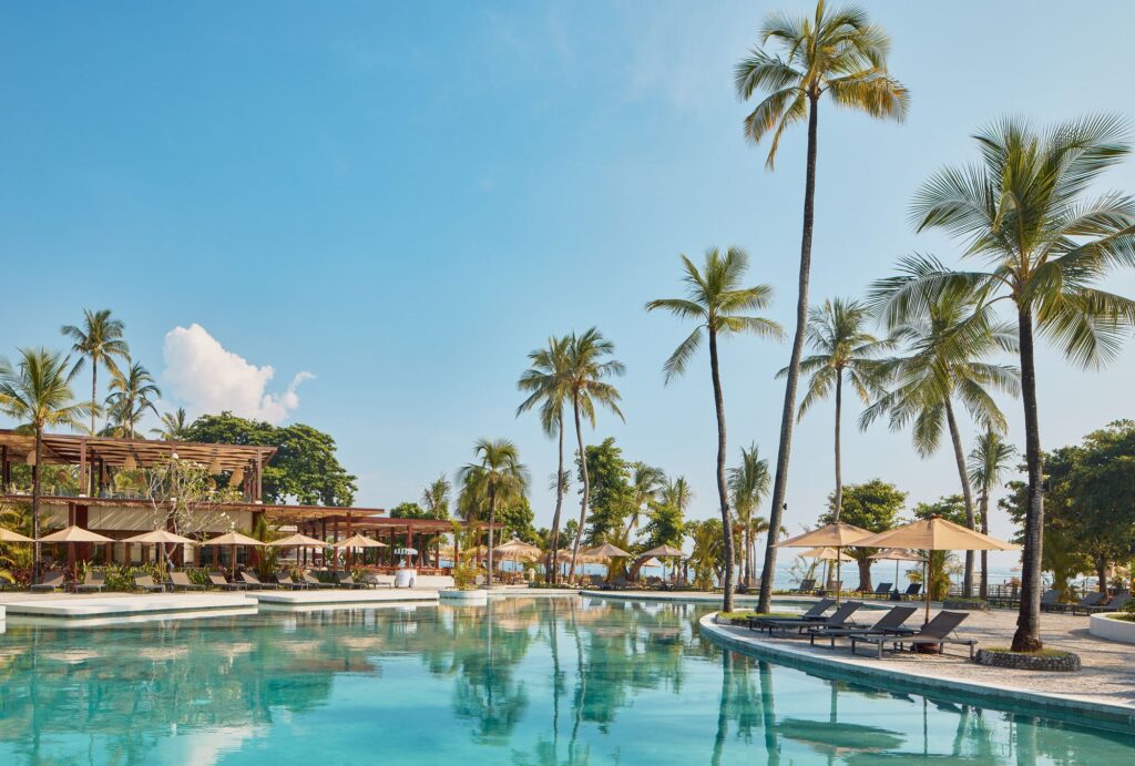 Main pool at Paradisus by Meliá Bali, lined with palm trees in Nusa Dua