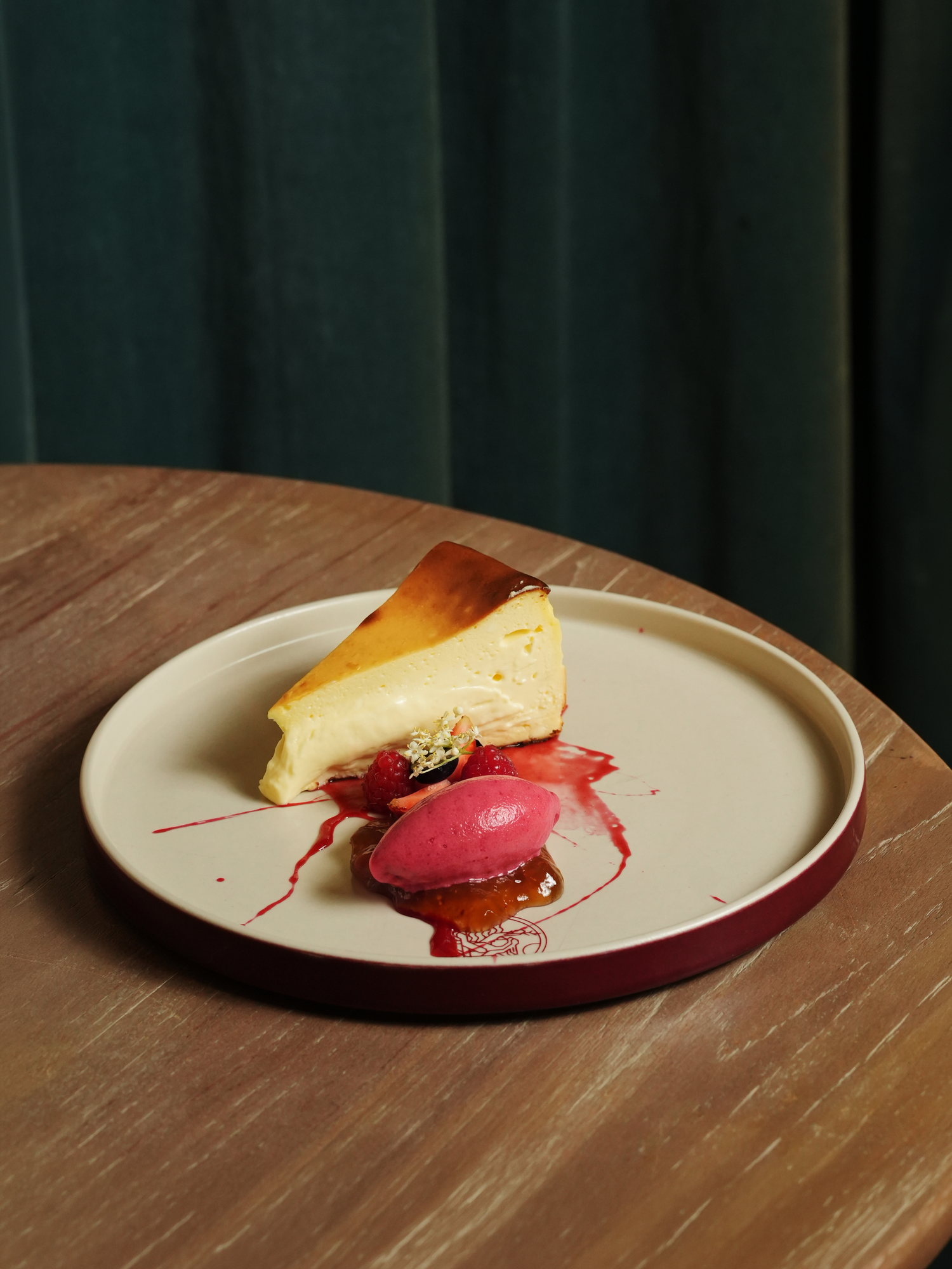 A slice of burnt Basque cheesecake with berry sorbet and raspberries at Peseta, Paradisus by Melia Bali