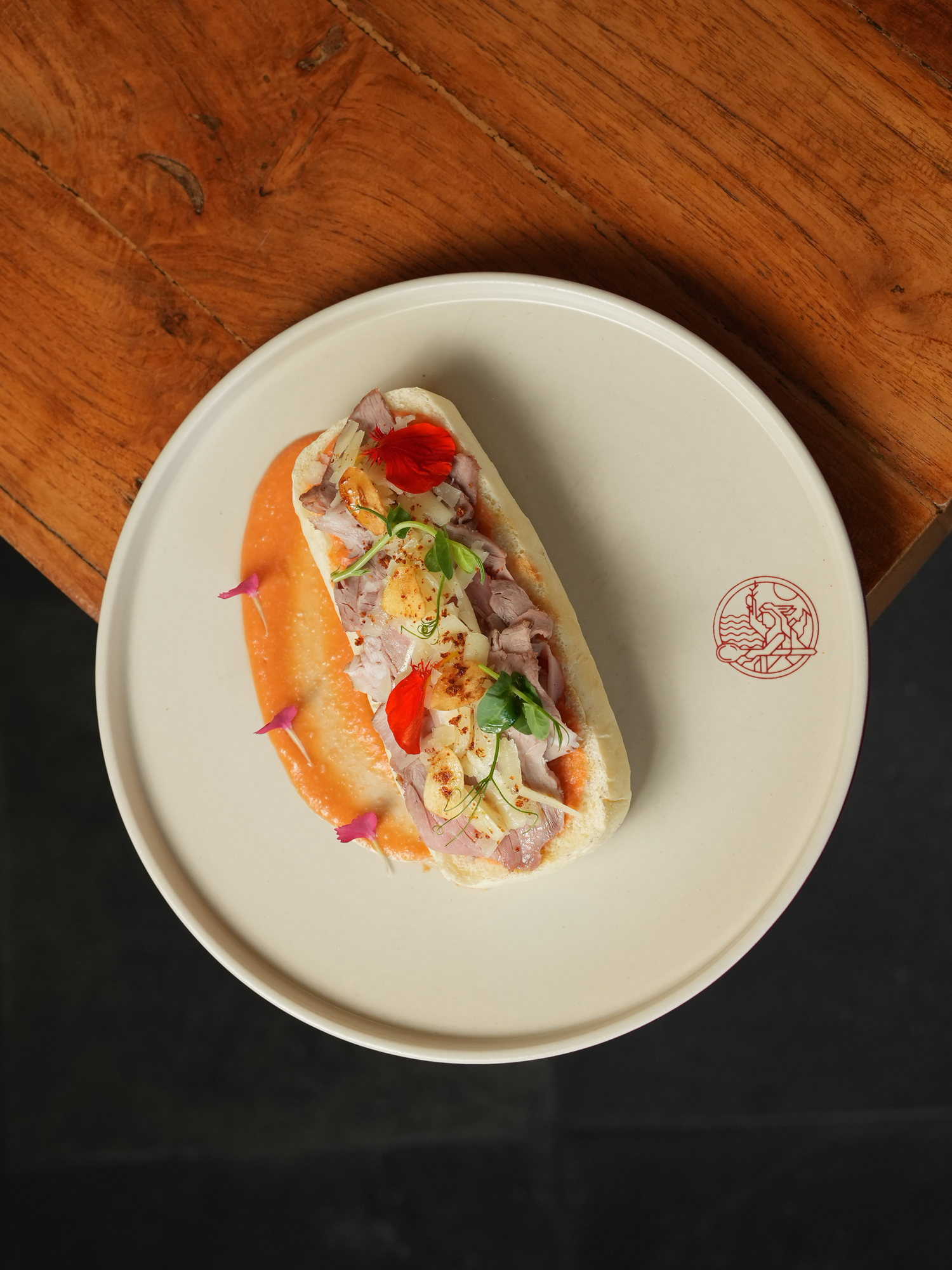 A soft roll filled with thin-sliced jamon and cheese on a pepper sauce at Peseta, Paradisus by Melia Bali