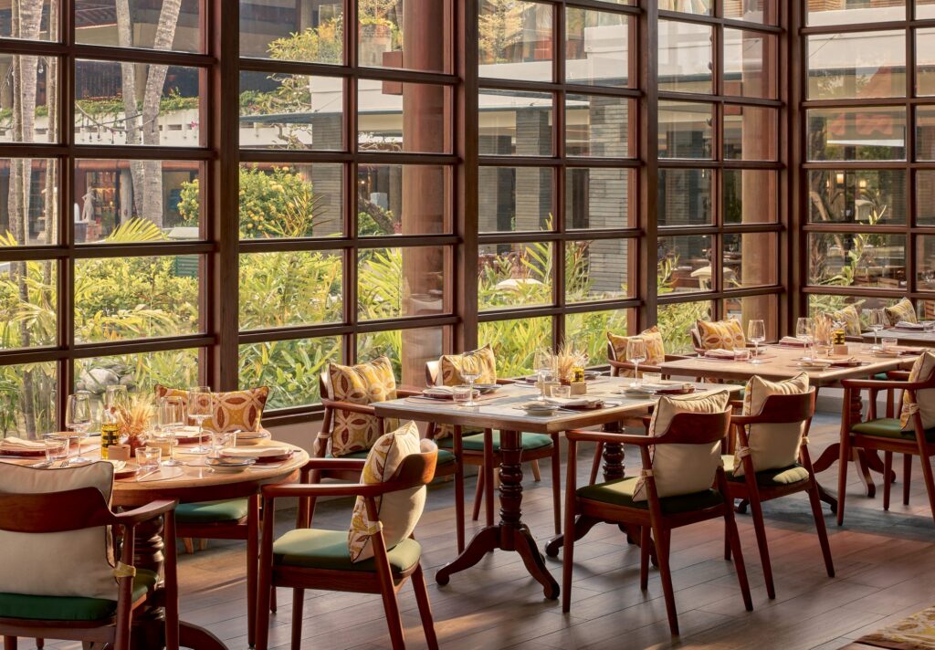 Peseta Spanish restaurant at Paradisus by Meliá Bali, tables set by tall windows onto the garden