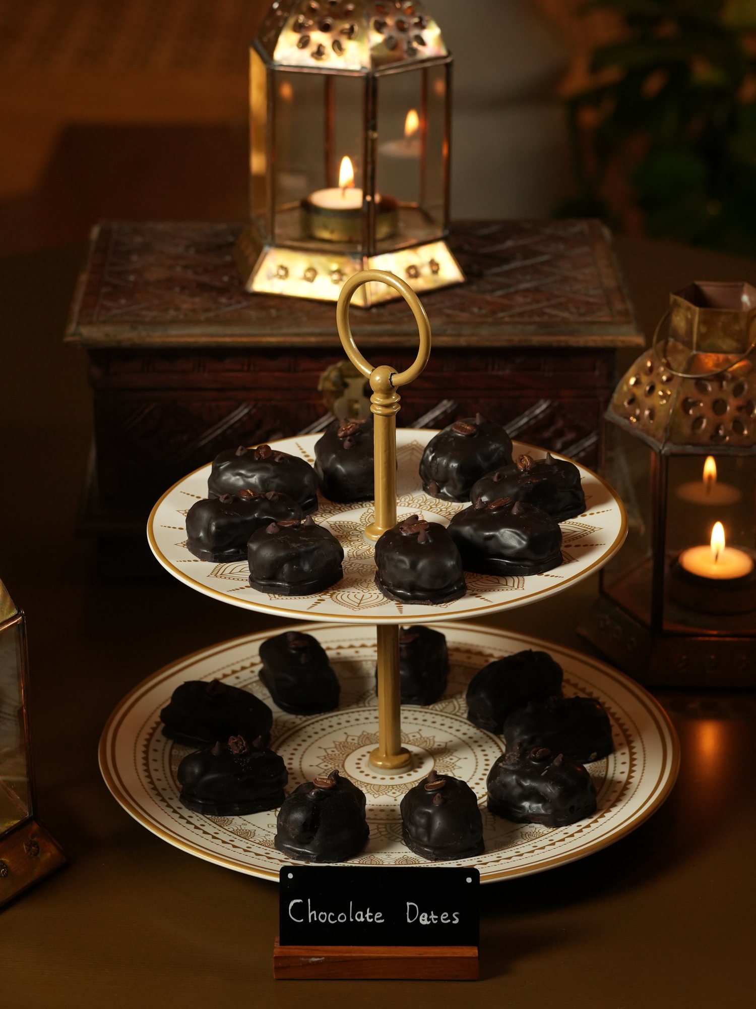 Chocolate-coated dates topped with coffee beans on a tiered stand by lantern light at Samira, Paradisus by Melia Bali
