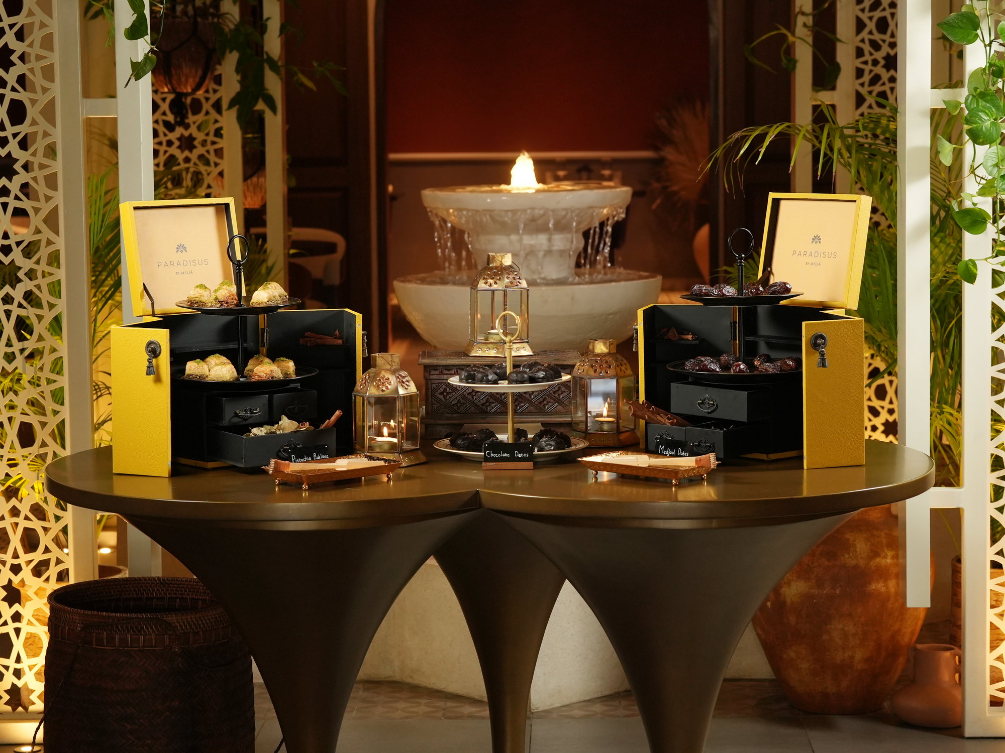 The dessert station at Samira, Paradisus by Melia Bali: pistachio baklava, chocolate dates and Medjool dates in brass-trimmed chests beside a fountain