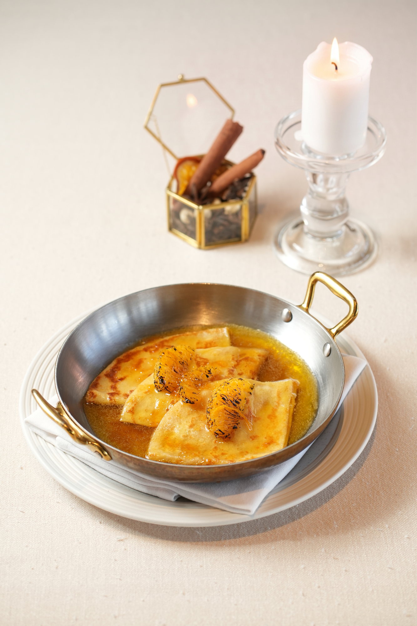 Folded crepes in an orange butter sauce with caramelised orange segments, served in a copper pan at Sante, Paradisus by Melia Bali