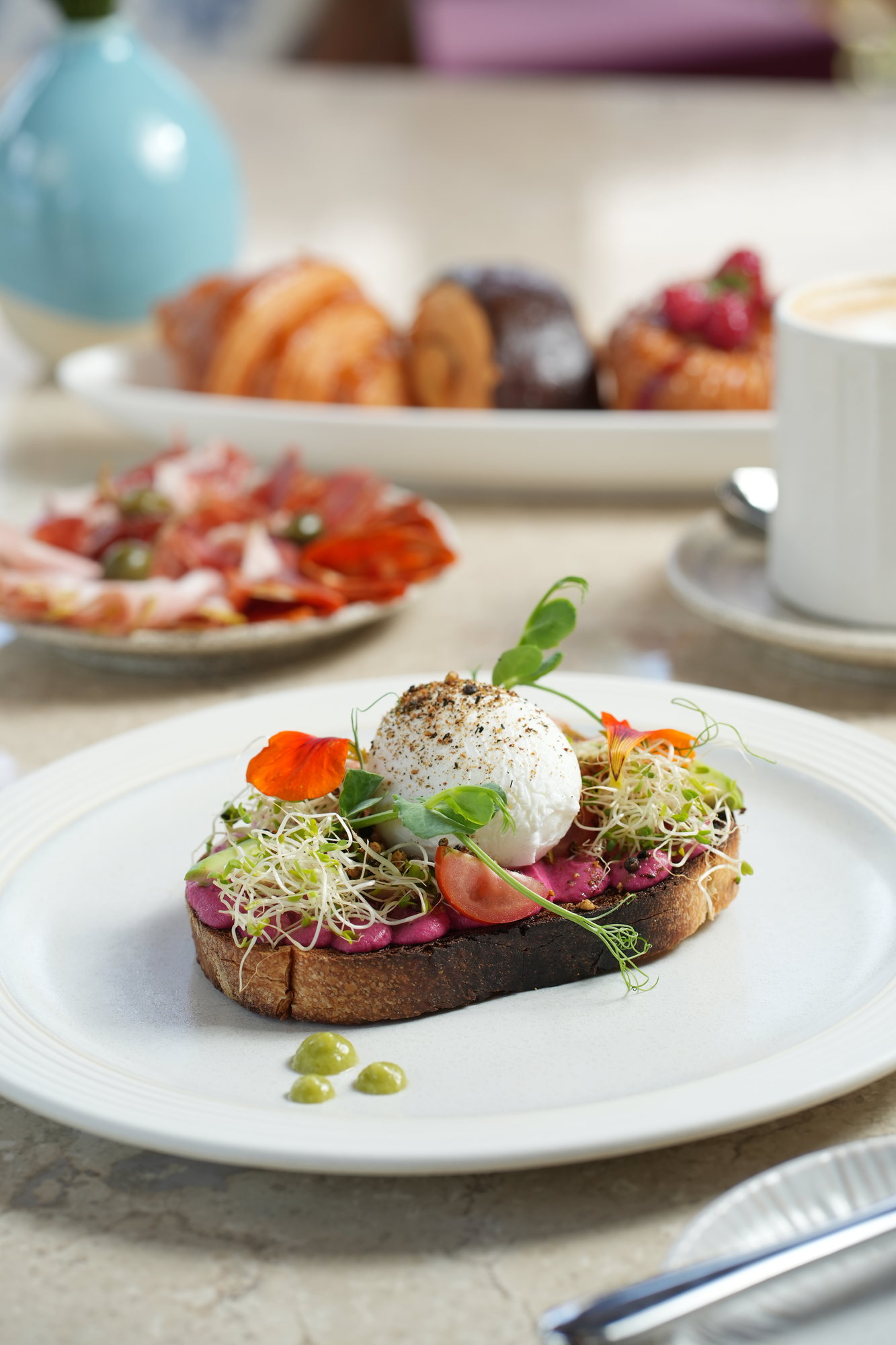 A poached egg on beetroot hummus and avocado toast with sprouts and nasturtium flowers at Sante, Paradisus by Melia Bali