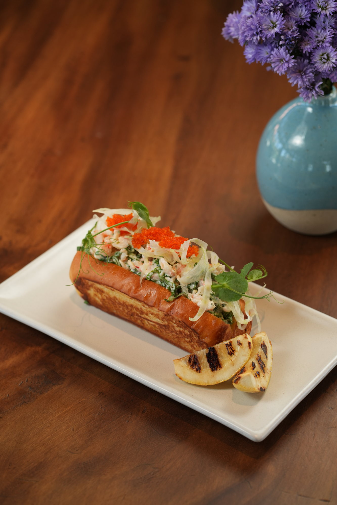 A brioche roll filled with seafood, shaved fennel and flying-fish roe, with grilled lemon, at Sante, Paradisus by Melia Bali