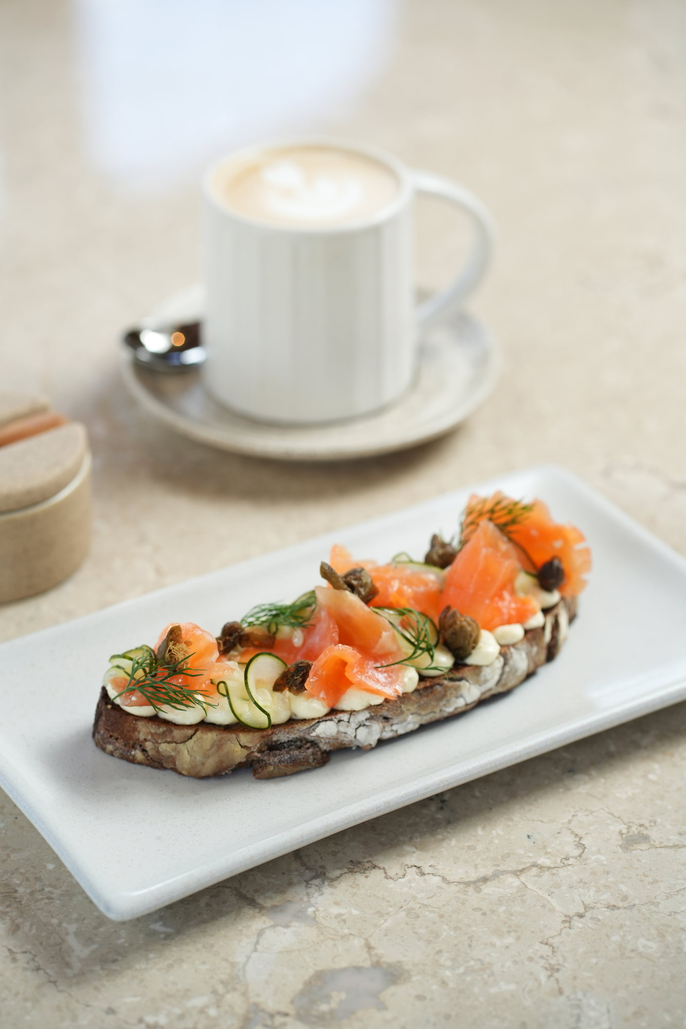 Smoked salmon on sourdough with whipped cream cheese, capers, dill and cucumber, with a cappuccino, at Sante, Paradisus by Melia Bali