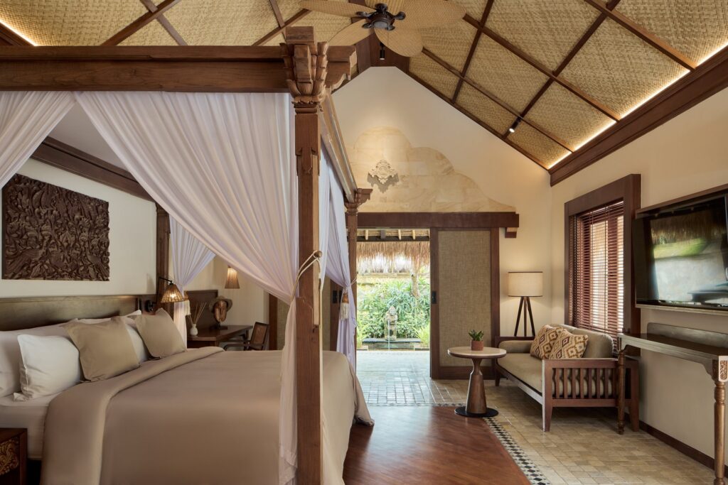 A Garden Villa bedroom at The Reserve, Paradisus by Meliá Bali, with a four-poster bed in white drapes under a pitched wooden ceiling
