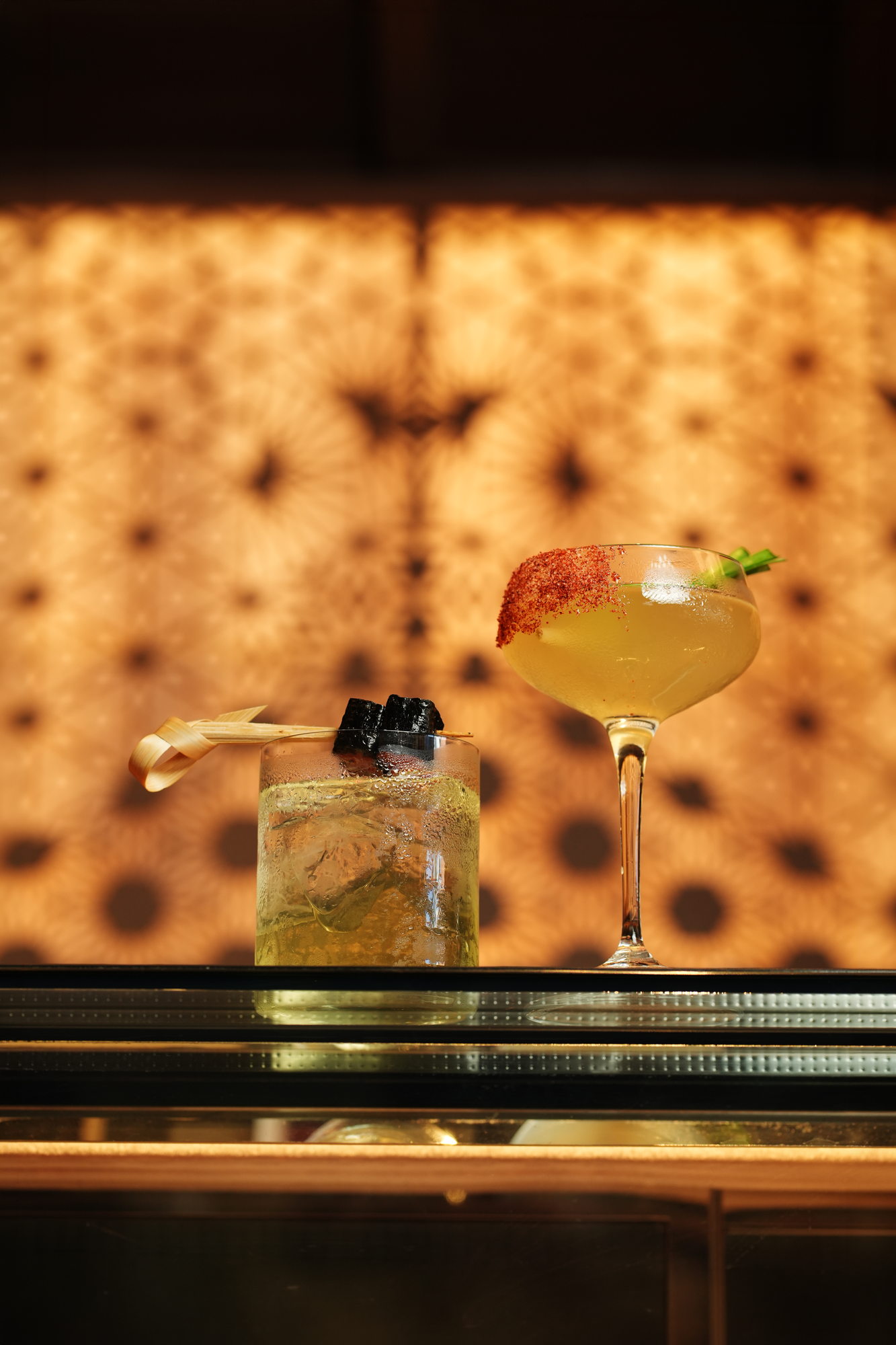 Two cocktails at the Tokimeku bar, Paradisus by Melia Bali: a highball with charred skewer and a chilli-rimmed coupe with lemongrass