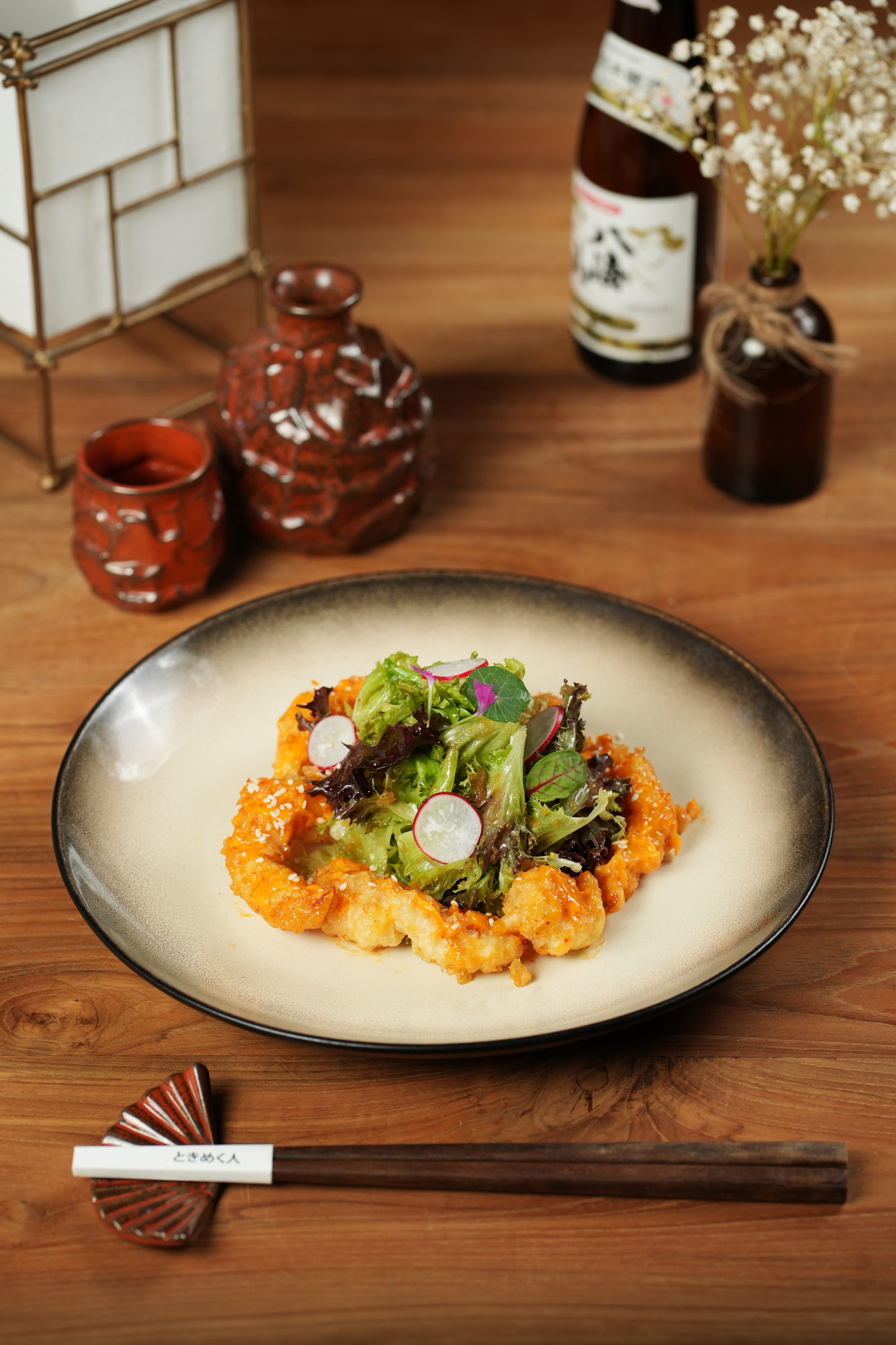 Crispy prawns in a sesame chilli glaze ringed around a small leaf salad with radish at Tokimeku, Paradisus by Melia Bali
