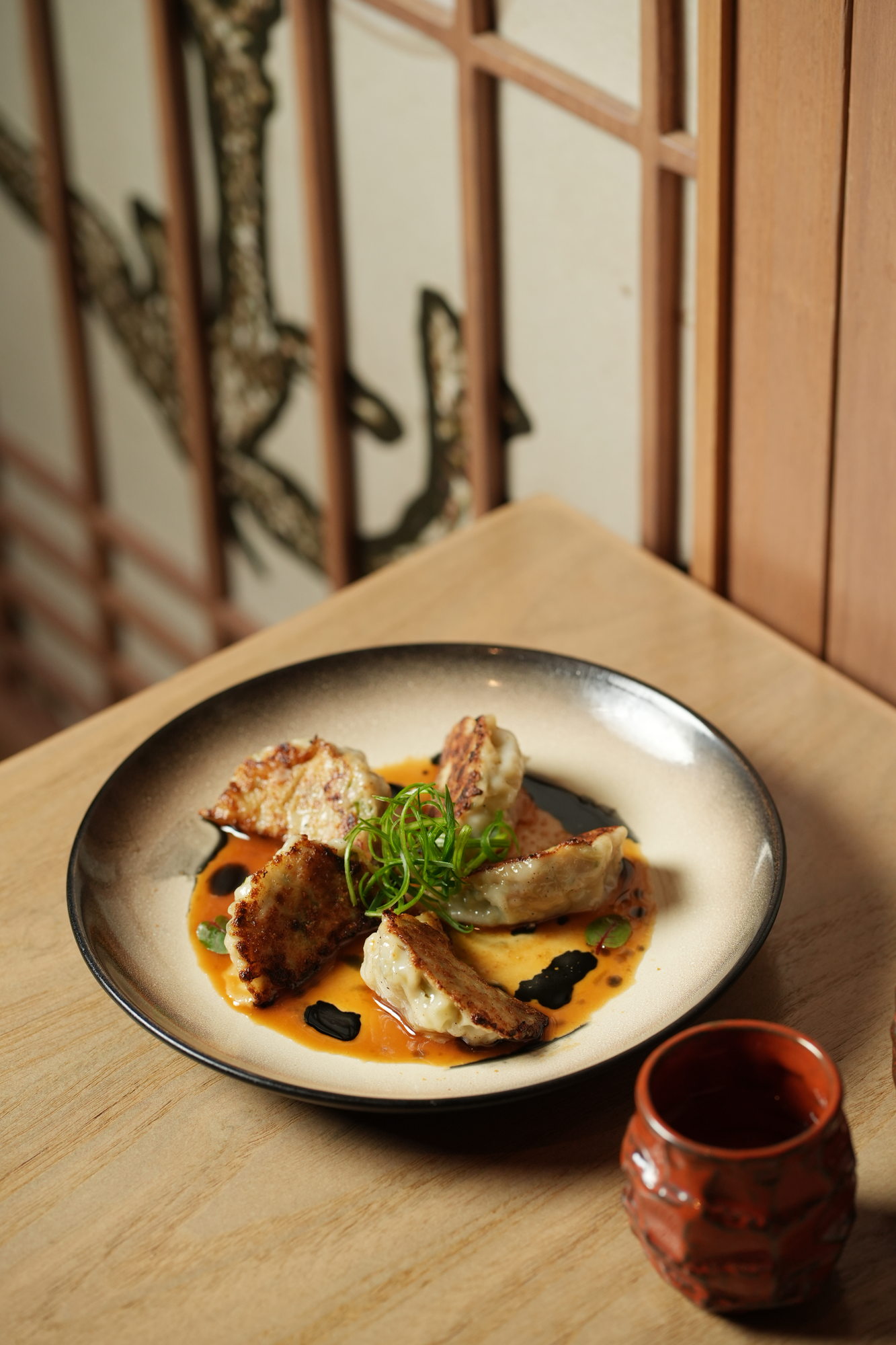 Pan-fried gyoza with spring onion in a spiced broth with black garlic at Tokimeku, Paradisus by Melia Bali
