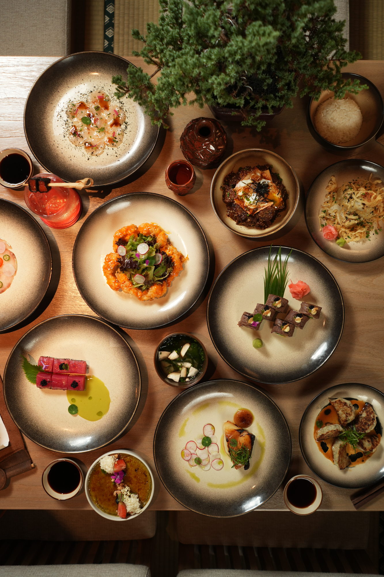 The same Tokimeku table seen from above at Paradisus by Melia Bali: scallop carpaccio, tuna, crispy prawns, beef-wrapped rolls, black cod, gyoza, beef donburi and creme brulee
