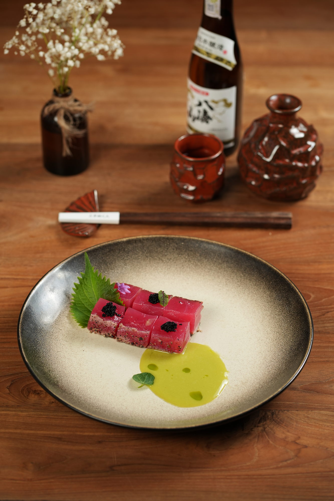 Blocks of pepper-crusted tuna topped with caviar on a shiso leaf, with a green herb sauce, at Tokimeku, Paradisus by Melia Bali