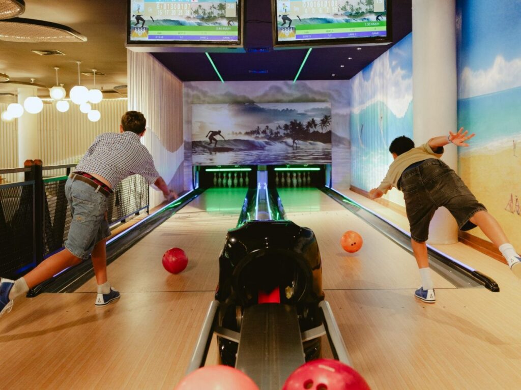 Two teenagers bowling on the lanes at YOURWAY Teen Club, Paradisus by Meliá Bali