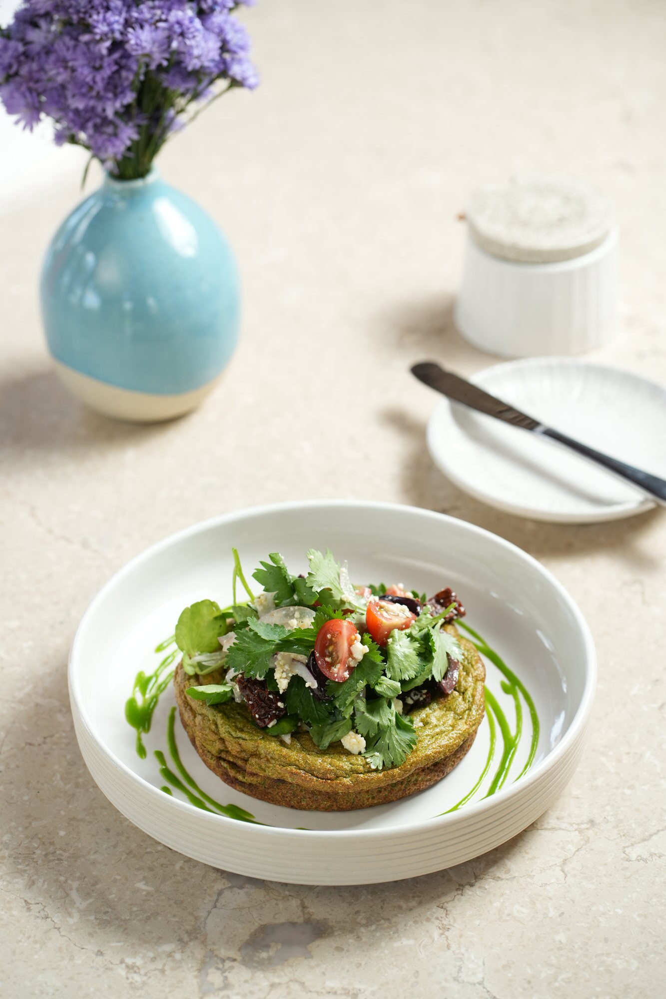 A herb-green omelette topped with coriander, feta, sun-dried tomato and cherry tomatoes at Sante, Paradisus by Melia Bali