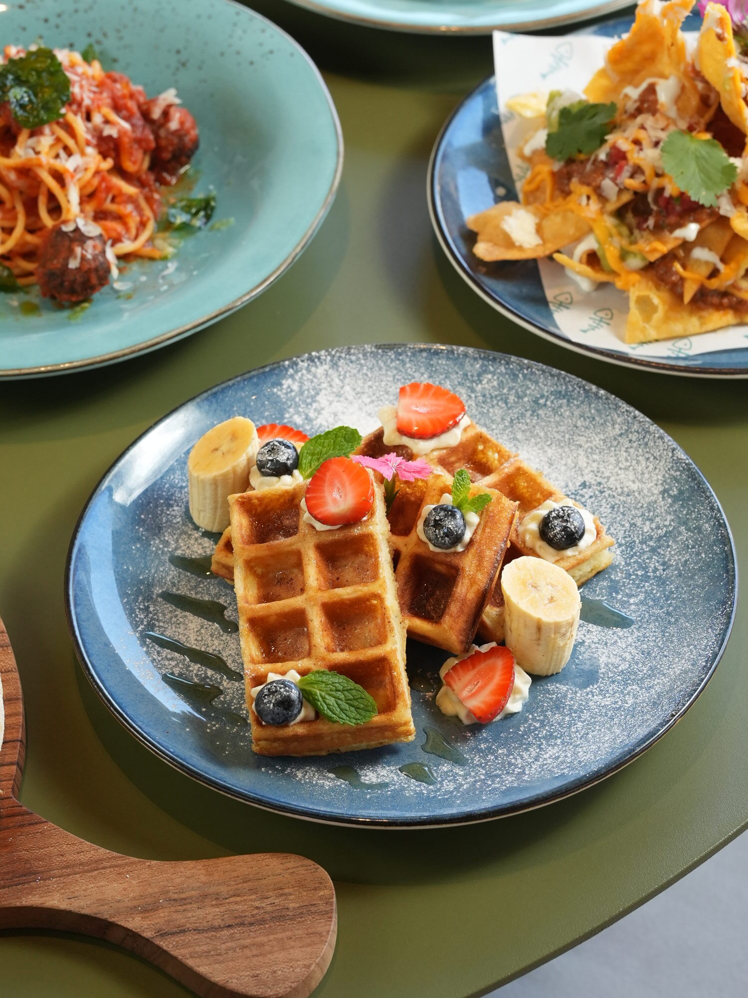 Waffles with berries and banana beside spaghetti and meatballs and loaded nachos at The Shack, Paradisus by Melia Bali